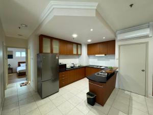 una cocina con nevera de acero inoxidable y armarios en StayInn Gateway Hotel Apartment, 2-bedroom Kuching City PrivateHome en Kuching