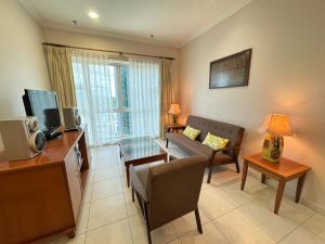 クチンにあるStayInn Gateway Hotel Apartment, 2-bedroom Kuching City PrivateHomeのリビングルーム(ソファ、テレビ付)