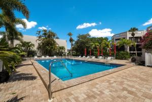 a swimming pool in a resort with palm trees at Sunbow Bay 108 condo in Holmes Beach