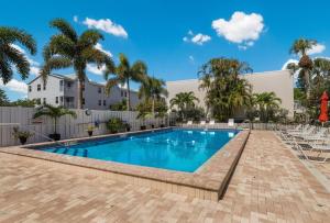 a swimming pool with palm trees and a building at Sunbow Bay 108 condo in Holmes Beach