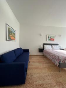 sala de estar con cama y sofá azul en Appartamento Barbieri, en Bolonia