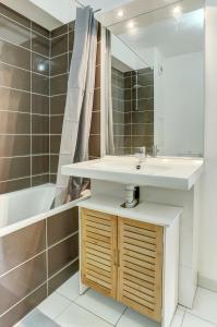 ein Badezimmer mit einem Waschbecken und einer Badewanne in der Unterkunft Le Curie - Saint Cyr in Saint-Cyr-lʼÉcole