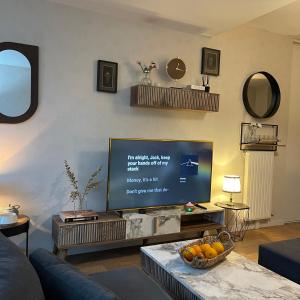 een woonkamer met een grote flatscreen-tv bij Appart Cosy Rennes Courrouze, 5min métro. in Saint-Jacques-de-la-Lande