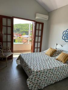 a bedroom with a large bed and a large window at Villa Paradiso Buzios in Búzios