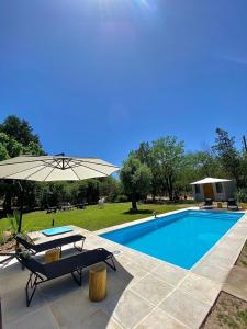 einen Pool mit einem Tisch und einem Sonnenschirm in der Unterkunft Magnolia Suites in Nono