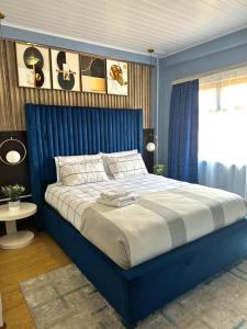 a blue bed in a bedroom with a blue wall at Exquisite short and long stay in Gaborone