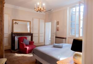 a bedroom with a bed and a red chair at Spacieuse demeure Albigeoise 5 pers + patio privé in Albi