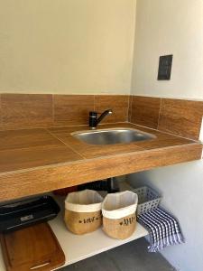 a kitchen counter with a sink and two baskets at Magnolia Suites in Nono +51 photos