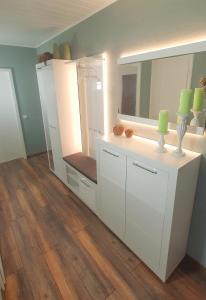 ein Badezimmer mit weißen Schränken und einem großen Spiegel in der Unterkunft Appartementwohnung Central Bad Sachsa in Bad Sachsa