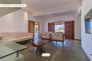 a living room with two couches and a table at Casa a 150m da praia no Pontal do Maceió por Tactu in Maceio