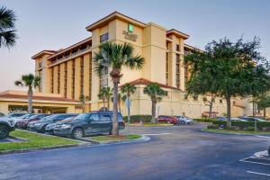 奥兰多Embassy Suites by Hilton Orlando North的一座大楼，停车场里停满了汽车