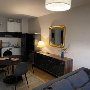een woonkamer met een bank en een tafel met een spiegel bij Appart Cosy Rennes Courrouze, 5min métro. in Saint-Jacques-de-la-Lande