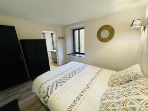 a bedroom with a bed and a mirror on the wall at Villa du Parc Le Pin in Formiguères