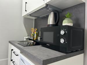 a kitchen counter with a microwave and a sink at SKY Apartments Hannover in Hannover
