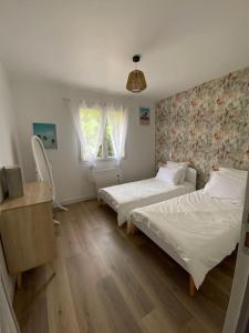 ein Schlafzimmer mit 2 Betten und einer Kommode darin in der Unterkunft La casa de Valentin in Yvrac