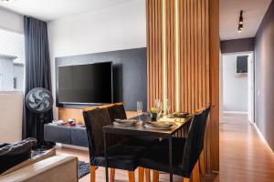 a dining room with a table with chairs and a television at Apartamento Autódromo de Interlagos sp in Sao Paulo