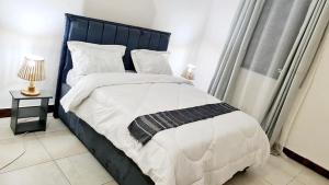 1 cama con cabecero azul en un dormitorio en Luxurious apartment with King size bed, en Dar es Salaam