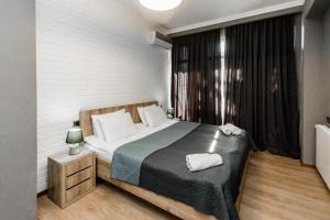 een slaapkamer met een bed en een nachtkastje met handdoeken erop bij Chugurety Rooming in Tbilisi City