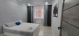 ein kleines Schlafzimmer mit einem Bett und einem Fenster in der Unterkunft Апартаменты на Кенесары 83 in Kökschetau
