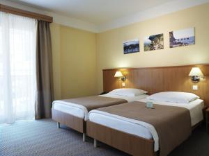 a hotel room with two beds and a window at Hotel Neptun - Terme & Wellness Lifeclass in Portorož