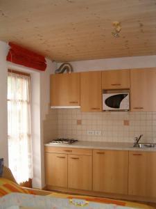 a kitchen with wooden cabinets and a microwave at Valtnerhof in San Candido