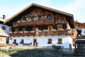 a house with flowers on the balconies of it at Valtnerhof in San Candido