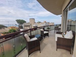 balcone con sedie e vista sulla città di ZagHouses - sea view apartments in Sicily ad Agnone Bagni