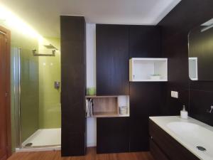 bagno con vasca, lavandino e doccia di ZagHouses - sea view apartments in Sicily ad Agnone Bagni