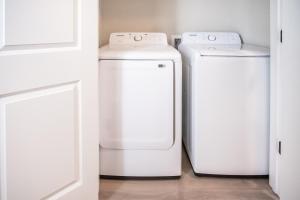 two white refrigerators sitting next to each other in a room at Bayou Bengal Royal Stay-n-Tailgate by LSU - BC1025 in Baton Rouge