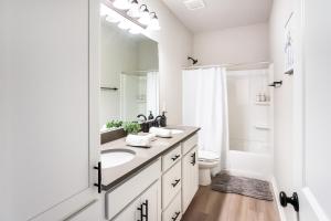 a white bathroom with a sink and a mirror at Bayou Bengal Royal Stay-n-Tailgate by LSU - BC1025 in Baton Rouge