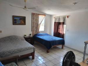 1 Schlafzimmer mit 2 Betten und einem Fenster in der Unterkunft Casa Tortuga - Excelente ubicación - Cerca de playa in Lázaro Cárdenas