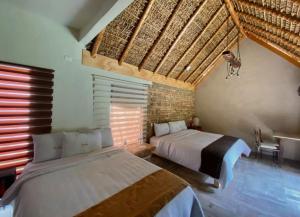 a bedroom with two beds in a room at Hotel Villas Mariposas in Atlixco
