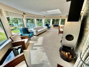 sala de estar con sofás, sillas y chimenea en Osmund House, Salisbury Sleeps up to 19 en Salisbury