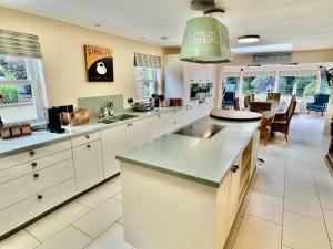 una gran cocina con armarios blancos y una gran isla en Osmund House, Salisbury Sleeps up to 19 en Salisbury
