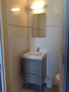 La salle de bains est pourvue d'un lavabo, d'un miroir et de toilettes. dans l'établissement Hôtel Restaurant de la Place, à Saint-Jean-dʼAngély