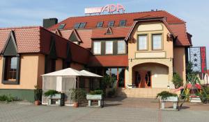 a building with two benches in front of it at Hotel Ada in Większyce