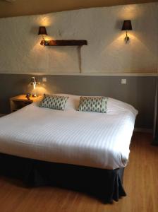 a bedroom with a large bed with two pillows at Hôtel Restaurant de la Place in Saint-Jean-dʼAngély