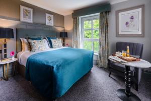 una camera con un letto blu e una finestra di Killarney Dromhall Hotel a Killarney