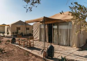 a yurt with a table and chairs on a patio at The Original Camp in Aït Daoud
