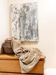 una pintura en una pared sobre un tocador de madera con una manta en apartamento muy próximo a Valencia en Burjasot