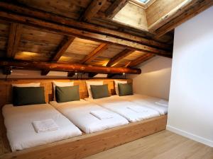duże łóżko w pokoju z drewnianymi sufitami w obiekcie La ferme d'Hauteluce - Chalets w mieście Hauteluce