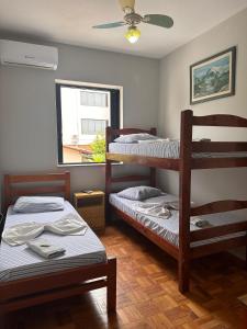a room with two bunk beds and a window at Hotel Bandeirantes de SJBV in São João da Boa Vista