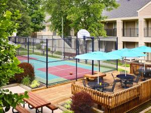 kort tenisowy ze stołami i parasolami na tarasie w obiekcie Sonesta ES Suites Atlanta - Perimeter Center North w Atlancie