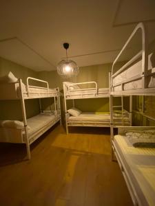 a room with three bunk beds and a chandelier at Rodin Hostel in Istanbul