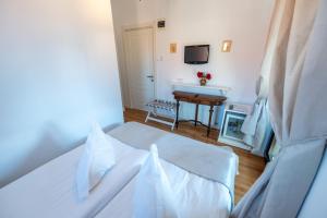 a bedroom with a bed and a desk with a television at Casa Din Bran - Inn Cuisine in Bran
