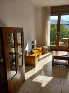 a living room with a television and a table at Apartaments Bell-Lloc Puigcerda in Puigcerdà