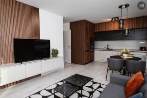 uma sala de estar com uma televisão grande e uma cozinha em AH Albelli em Košice