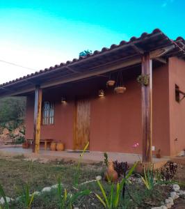 伊比科阿拉的住宿－Vila Sincorá - Chalé para 4 pessoas com cozinha a 2 km da portaria da Cachoeira do Buracão，一座带庭院的屋顶房子