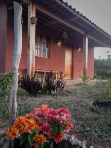 Vila Sincorá - Chalé para 4 pessoas com cozinha a 2 km da portaria da Cachoeira do Buracão في إيبوكوارا: منزل أمامه باقة ورد