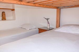 um quarto com duas camas e um vaso sobre uma mesa em Cabaña Rustica em Montebello